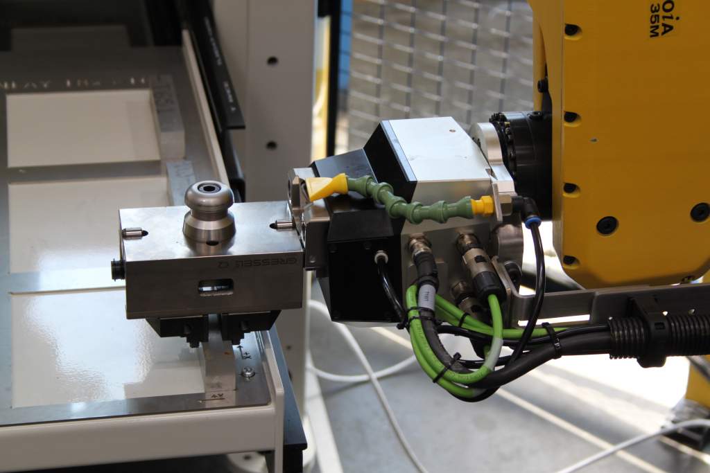 Der Roboter nimmt mit dem im Robotermodul eingespannten Zentrisch-Spanner ein Rohteil aus dem Tablar-Nest.