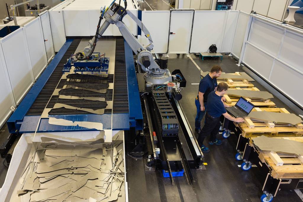 Trumpf hat gemeinsam mit Siemens und weiteren Partnern eine Laseranlage für die Blechbearbeitung entwickelt. Zwei Mitarbeiter bereiten sie für ihren vollautomatischen Einsatz vor.