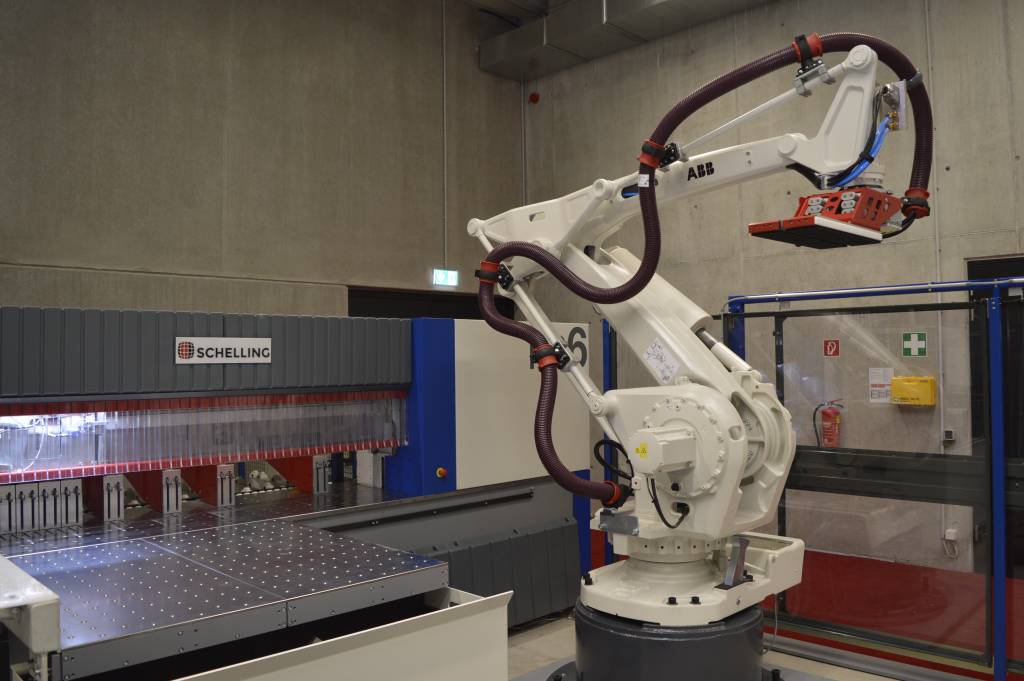 Der Roboter übernimmt nicht nur die Beschickung der Maschine, sondern auch das Handling des Rohmaterials und der Fertigteile.
