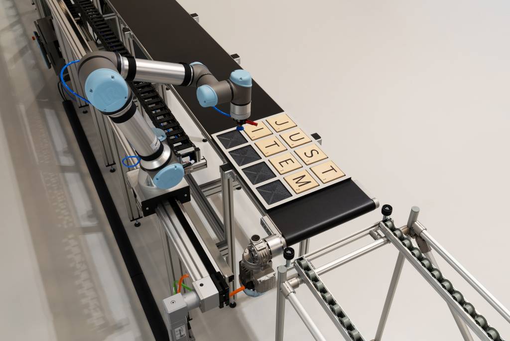 Konkretes Anwendungsbeispiel: Das Projekt „Range Extender“ besteht aus einem Cobot, der sich parallel zum Gurtförderer auf einer Linearachse bewegt. Während der synchronen Bewegung zum Band entnimmt der Roboter Bauteile und fügt sie neu zusammen.