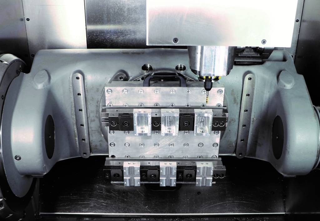Das Mehrfach-Spannsystem auf einer Wechselpalette mit Rastersystem montiert, die auf einem Nullpunkt-Spannsystem abgesteckt ist (Maschine: Hermle C250).