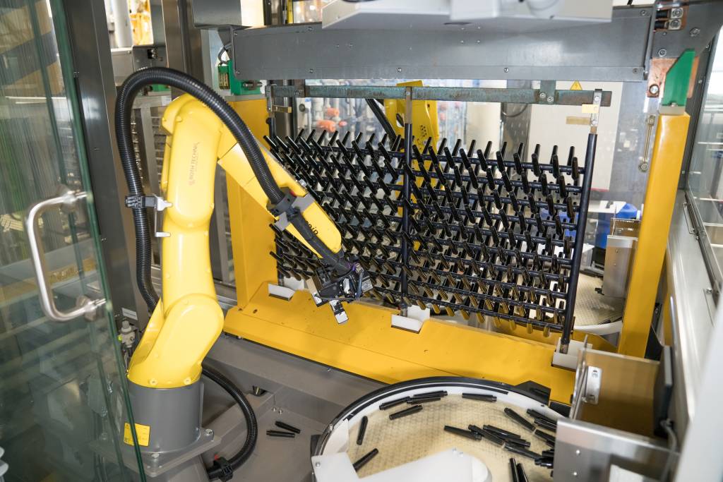 Mit zwei Roboterzellen nutzt das Beschichtungsunternehmen Collini den kleinen Galvanikbereich sehr effizient. Der Roboterarm bestückt die Haken vollautomatisch, bevor das Gestell ins Galvanikbad getaucht wird. Der Profilsensor OXM200 von Baumer lotst dabei den Roboter.