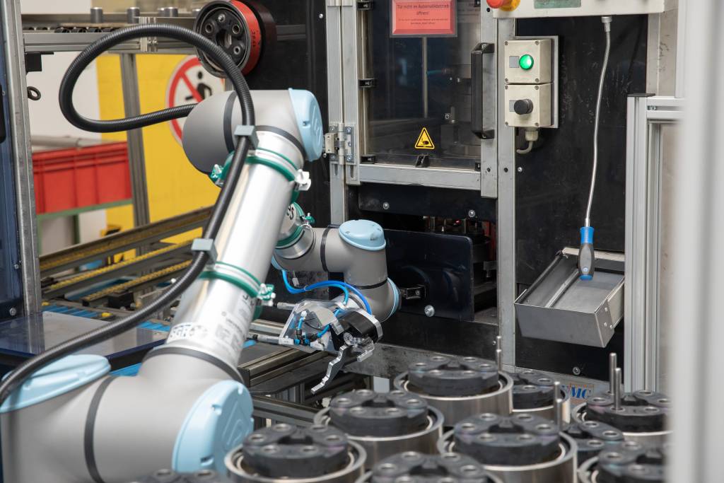 Ein UR10e von Universal Robots bestückt bei SGF eine Einpressstation und eine Auswuchtanlage mit Bauteilen.