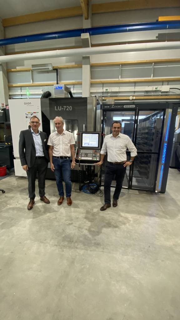 Jürgen Widmann (CEO, EVO), Klaus Hofmann (CEO, Zeroclamp) und Mario Sanna (Vertriebsleitung, Zeroclamp) vor der automatisierten Werkzeugmaschine mit Zerobot in der hauseigenen Fertigung.