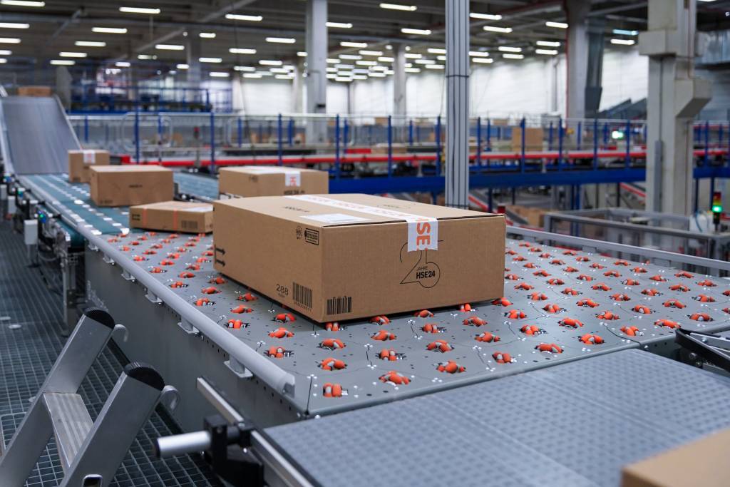 Mithilfe automatisierter Sortiertechnologie bereitet DHL Home Delivery im Logistikzentrum Greven Sendungen für HSE vor.
